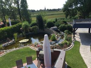 a garden with an umbrella and a pond at Ferienwohnungen in Wremen in Wremen