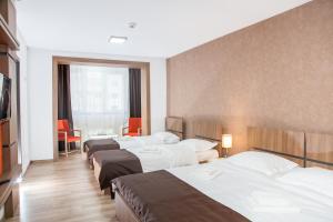 fila de camas en una habitación de hotel en HB Brilliant en Brasov