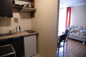 a small kitchen with a sink and a table and chairs at Nestor II in Mrzeżyno