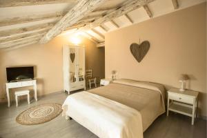 1 dormitorio con 1 cama con un corazón en la pared en 700enolocanda, en Santa Giuletta