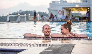 a man and a woman laying in a swimming pool at The Grand Kandyan in Kandy