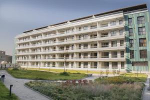 a large white building with a park in front of it at Ares ApartHotel in Cluj-Napoca