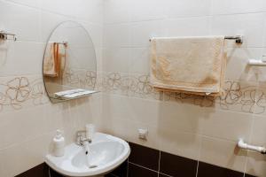 ein Bad mit einem Waschbecken und einem Spiegel in der Unterkunft Алтынай in Sibay