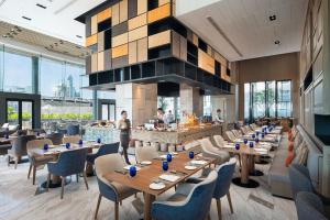 un restaurante con mesas y sillas de madera y chimenea en Hotel Nikko Bangkok - SHA Extra Plus Certified en Bangkok