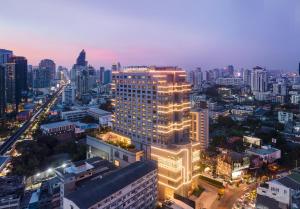 a lit up building in a city at night at Hotel Nikko Bangkok - SHA Extra Plus Certified in Bangkok