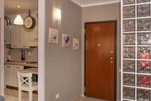 a kitchen with a door and a clock on the wall at Appartamenti Velez in Pisa