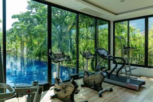 a gym with a view of a pool at Avani Ao Nang Cliff Krabi Resort in Ao Nang Beach