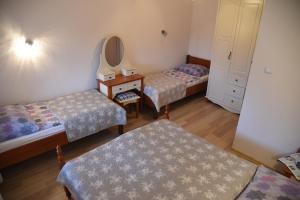 a room with three beds and a mirror and a dresser at Nestor in Mrzeżyno