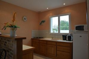 cocina con nevera blanca y ventana en Chateaubriand, en Saint-Cast-le-Guildo
