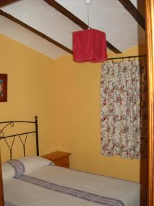 - une chambre avec un lit et une fenêtre avec un rideau dans l'établissement Casa Rural El Balcón de Cazorla, à Tiscar