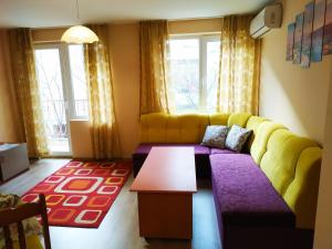 a living room with a yellow couch and a table at CITY STAY in Varna in Varna City