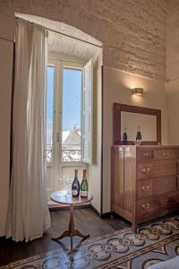 a room with a table with two bottles of wine at Perlage Suite Luxury B&B - Amazing view of Trulli in Alberobello