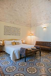 a bedroom with a king sized bed and a couch at Perlage Suite Luxury B&B - Amazing view of Trulli in Alberobello