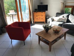 Sala de estar con silla roja y mesa de centro en Chateau de Barbet 124, en Lombez