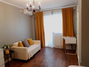 a living room with a couch and a window at D&C Studio in Bucharest