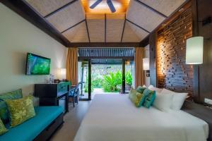 una camera da letto con un grande letto bianco e un divano di Impiana Beachfront Resort Patong, Phuket a Patong Beach Altre 81 foto