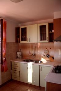 a kitchen with white cabinets and a sink at Apartman Slavko in Zverinac