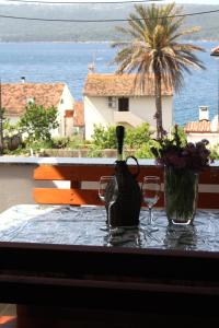 a table with two glasses and a bottle of wine at Apartman Slavko in Zverinac