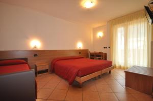 アンダロにあるResidence Alba Novaの赤いベッドとソファが備わるホテルルームです。