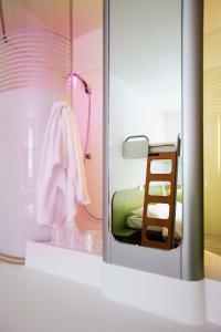 a small room with a bunk bed and a mirror at Ibis budget Wien Messe in Vienna