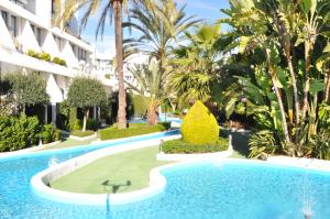 einen Pool in einem Resort mit Palmen in der Unterkunft Marbella House Penthouse 85 in Marbella