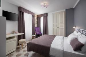 a bedroom with a bed and a table and a desk at Noemi's rooms in Rovinj