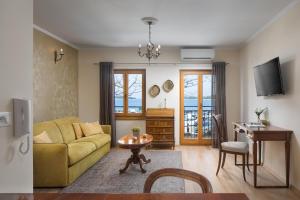a living room with a yellow couch and a table at Valdibora Sea View Residence in Rovinj