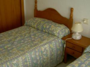 ラ・マンガ・デル・マール・メノールにあるBertur Hawaiiのベッドルーム1室(ベッド2台、ナイトスタンドのランプ付)