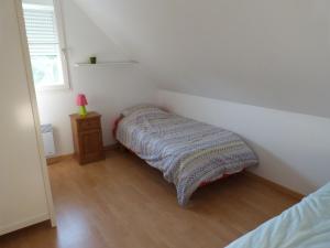 a small bedroom with a bed and a night stand at Chez Grace in Wissant