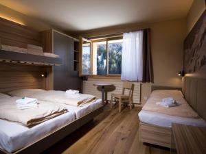 a hotel room with two beds and a table at JUFA Hotel Malbun in Malbun +66 photos