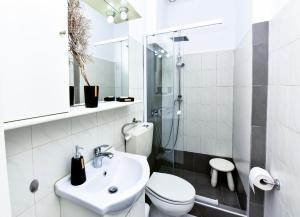 a white bathroom with a sink and a toilet at Kyano House in Limenas +67 photos
