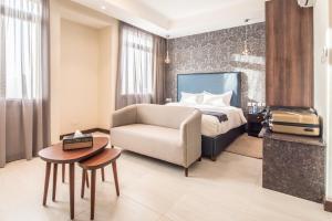 a hotel room with a bed and a couch and a chair at Glam Hotel Nairobi - Near Westgate Mall, Westlands in Nairobi