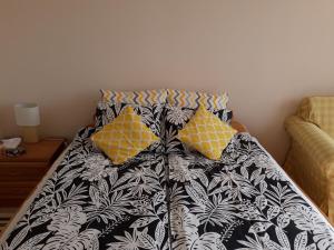 a bed with black and white sheets and yellow pillows at Apartament Czwarte Piętro in Świecie