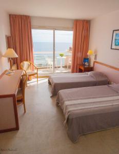 a hotel room with two beds and a balcony at Association Villa Saint Camille in Théoule-sur-Mer