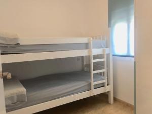 a couple of bunk beds in a small room at Apartamento en playa Gandia con piscina y parking in Playa de Gandia +25 photos