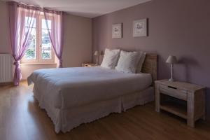 Un dormitorio con una cama grande y una ventana en Les Voyageurs, en Saint-Martin-la-Méanne
