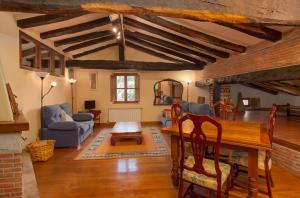 a living room with a table and chairs and a couch at Casona De La Salceda in Treceño