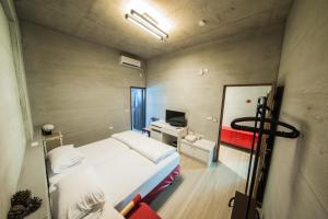a small room with a bed and a mirror at Mao House in Magong