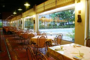 un restaurante vacío con mesas y sillas y una ventana en Rainbow Resort Hotel, en Wenquan