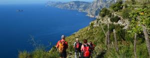 un gruppo di persone che camminano su una collina che domina l'oceano di Villamena a Furore