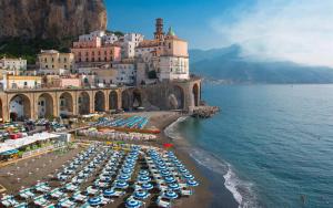 un gruppo di ombrelloni e sedie in spiaggia di Villamena a Furore