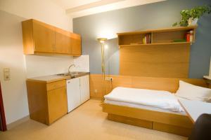 ein kleines Schlafzimmer mit einem Bett und einem Waschbecken in der Unterkunft Kolping Gästehaus in Klagenfurt am Wörthersee