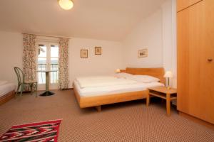 1 dormitorio con cama, mesa y ventana en Hotel Seehof en Maria Wörth