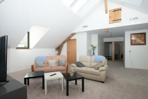 a living room with two couches and a tv at Ô jardin de boutancourt in Boutancourt