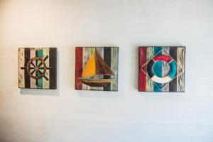 four pieces of art hanging on a wall at Mao House in Magong