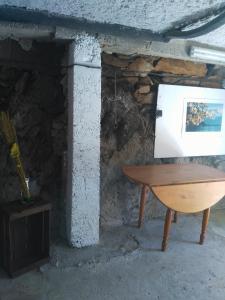 Saint-Vincent的住宿－Le camélia de la mazarié，石壁炉前的木桌