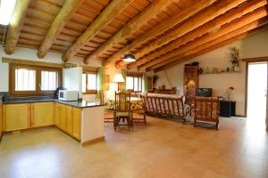 uma cozinha e sala de estar com mesa e cadeiras em Apartamento con jardín, barbacoa y piscina en pleno Montseny Mas Romeu Turisme Rural em Arbúcies