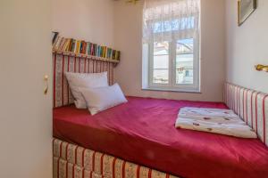 a bedroom with a red bed with a window at Goga in Selce +21 photos