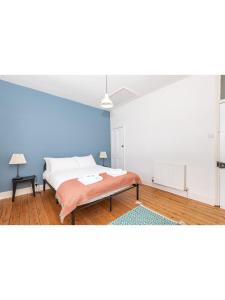 1 dormitorio con cama y pared azul en Bright & Beautiful Period Property - Pass the Keys, en York