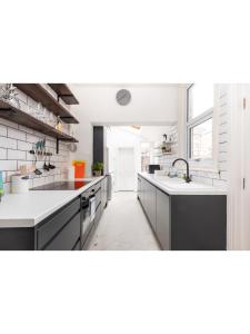 a large kitchen with white counters and a sink at Bright & Beautiful Period Property - Pass the Keys in York